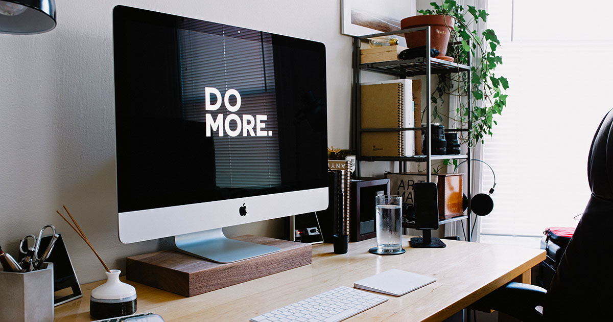 iMac on a desk with sign Do more