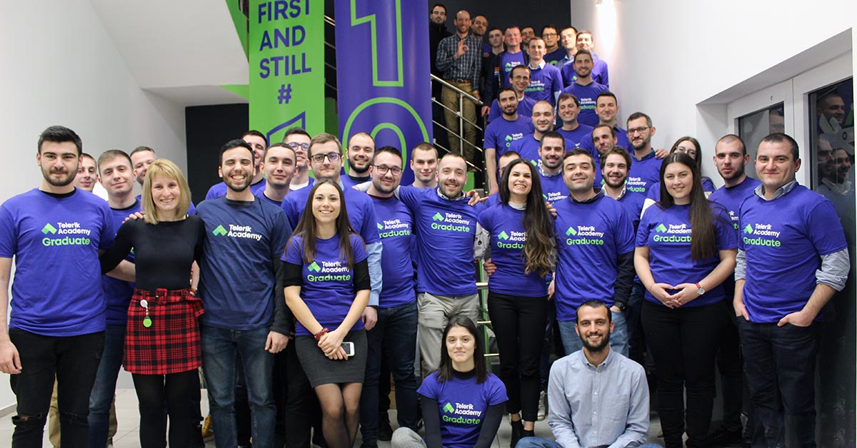 Telerik Academy graduates posing for a picture with t-shirts with telerik academy logo and name