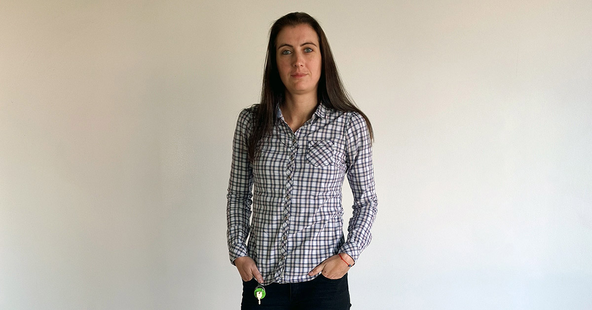 Telerik Academy Alpha graduate in a shirt with square pattern in front of a white wall at Tick42's office