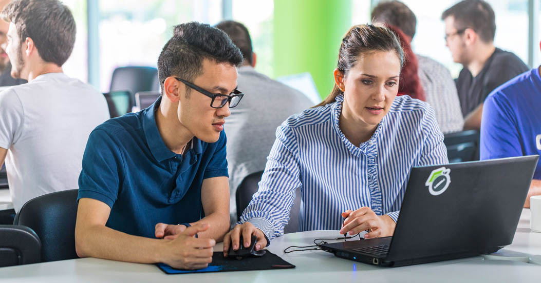 Two Telerik Academy students discussing a task during classes